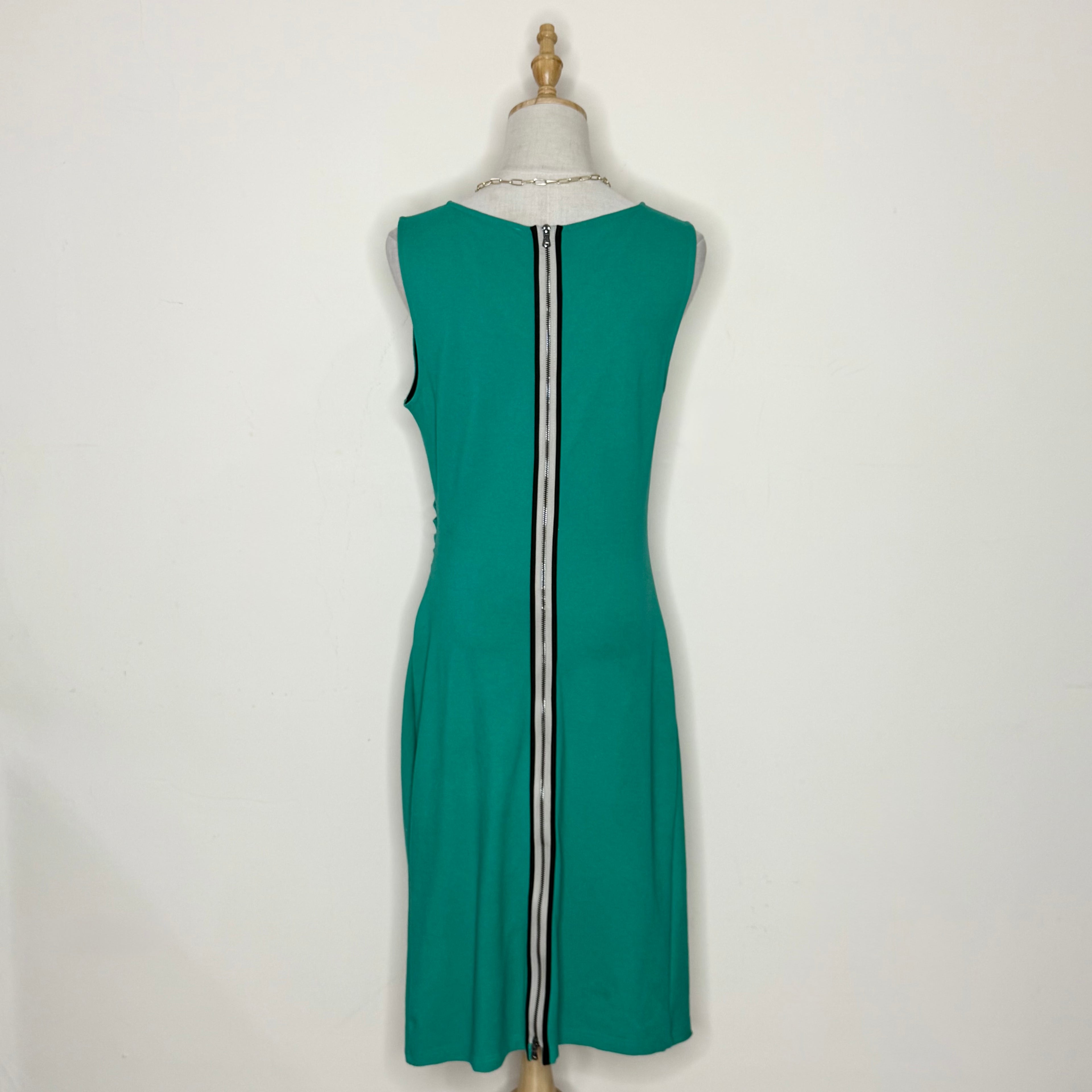 Green dress on a mannequin against a white background
