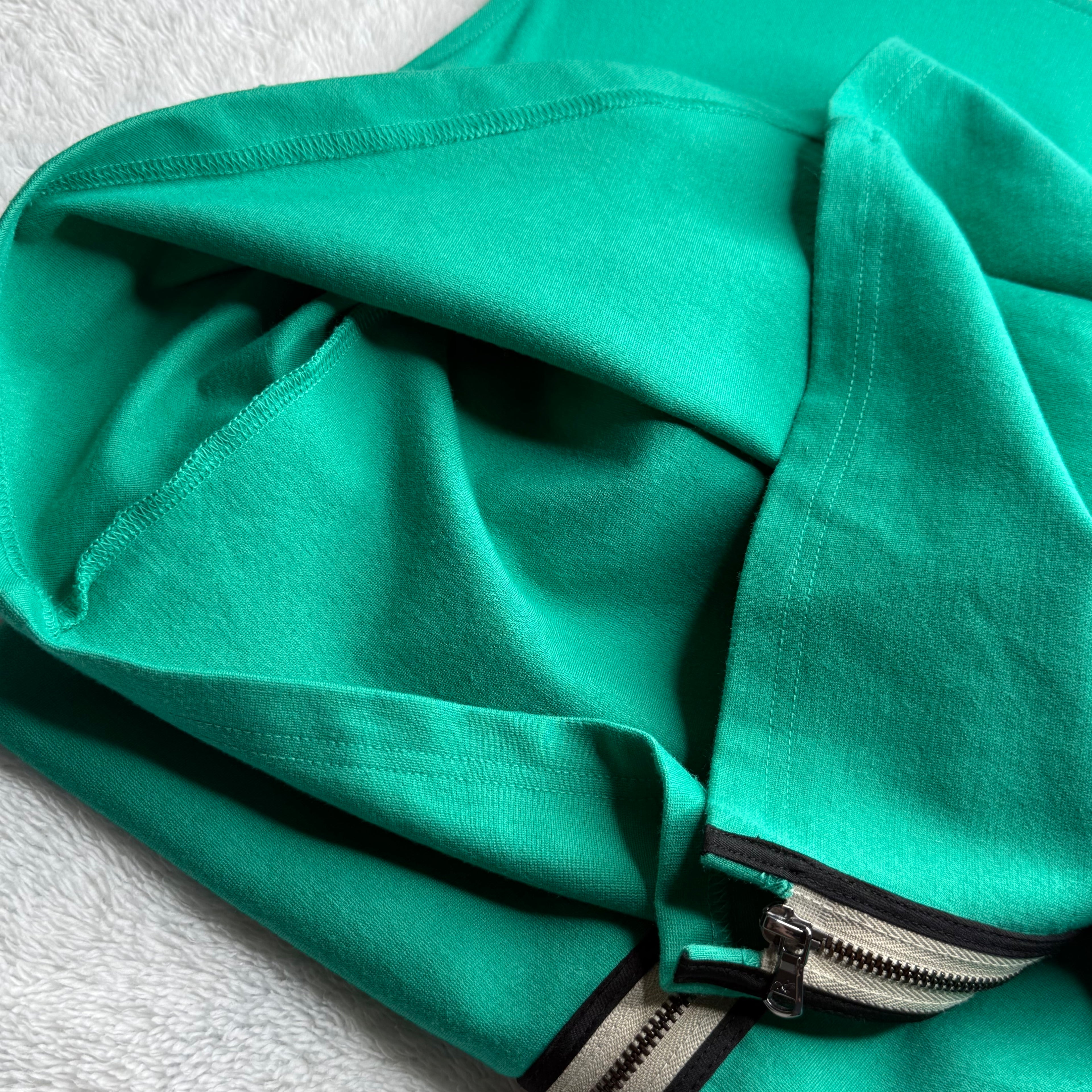 Close-up of a green jacket with a zipper on a light gray background