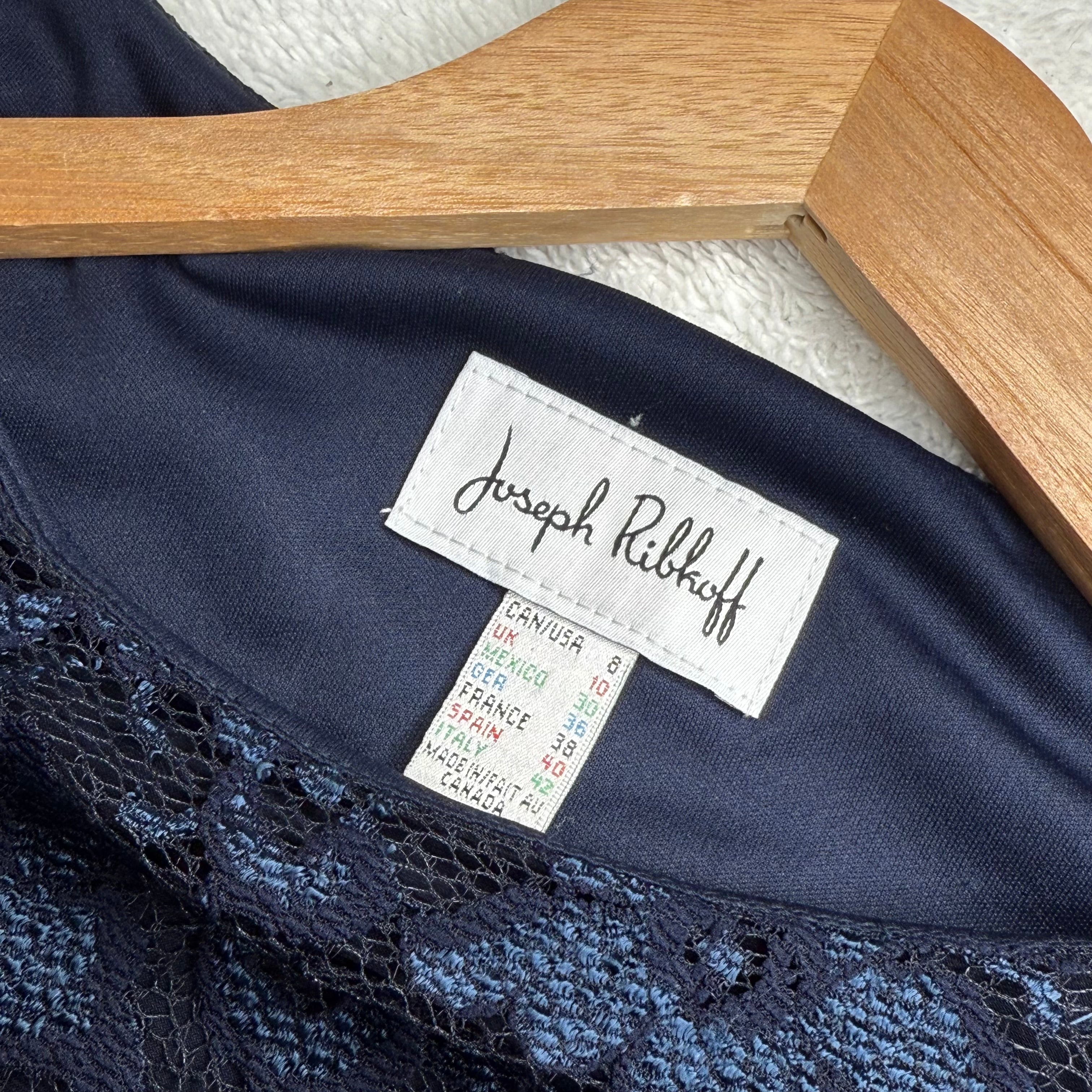 Navy lace garment with a Joseph Ribkoff label on a wooden hanger.