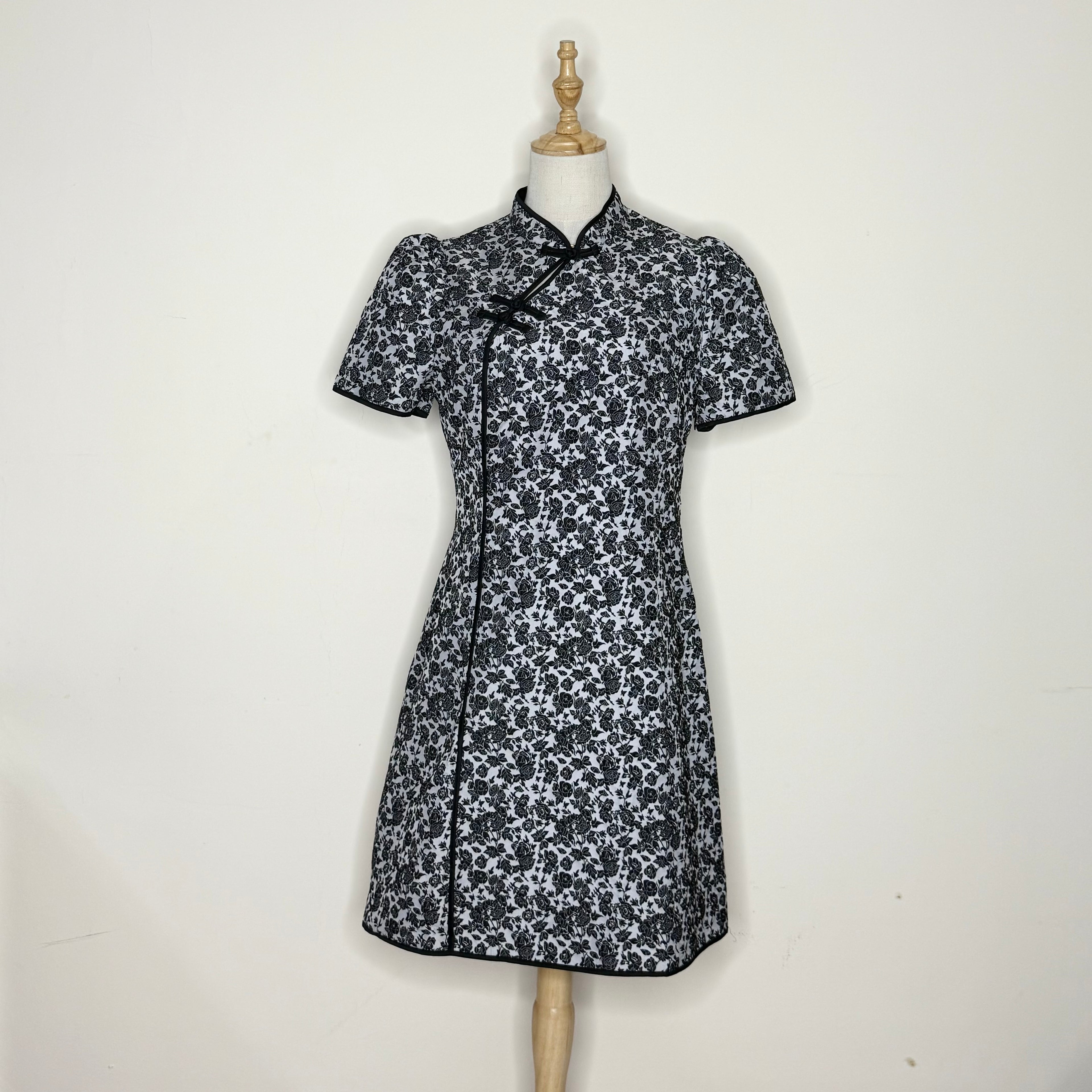 Black and white floral dress on a mannequin against a white background