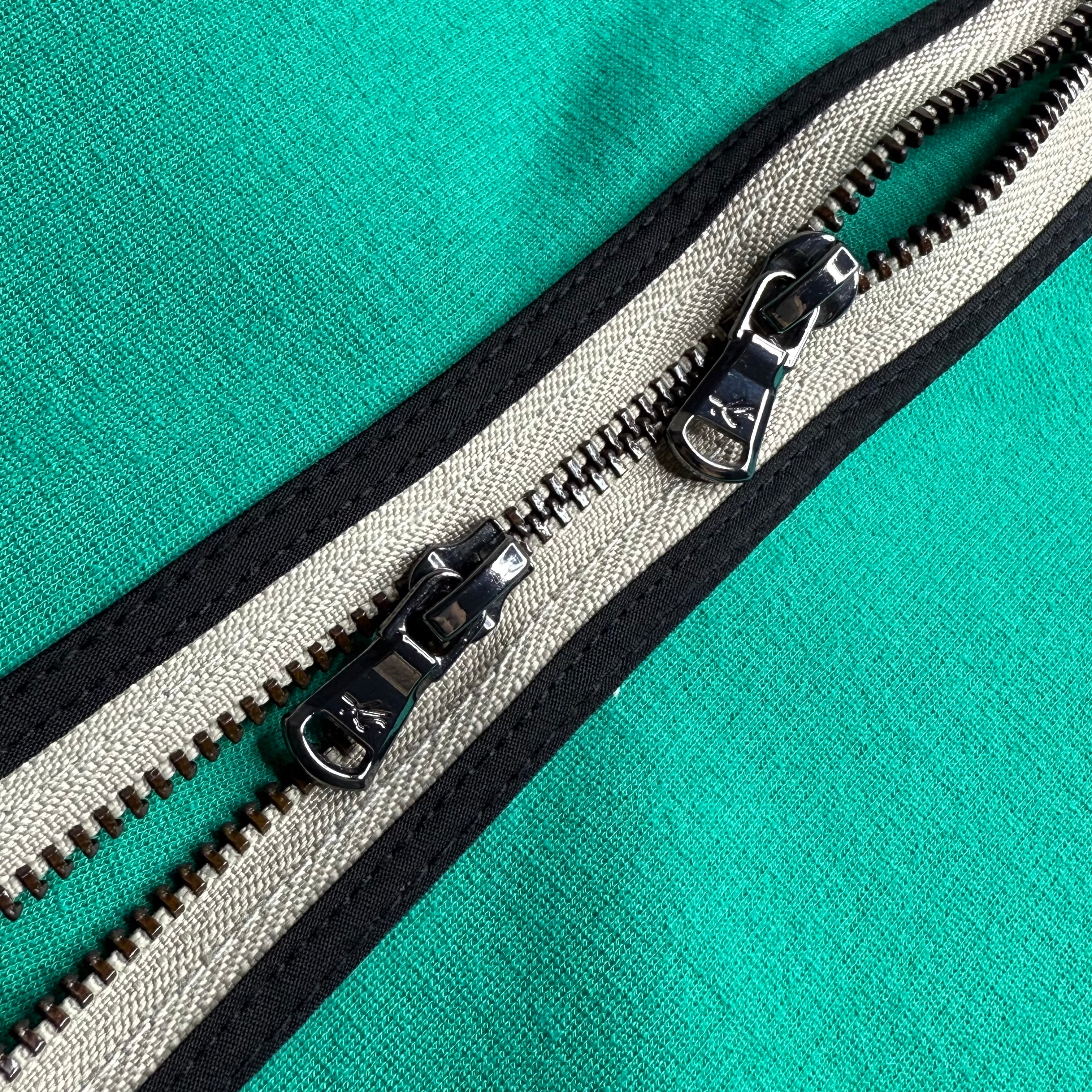 Close-up of a zipper on a teal fabric background
