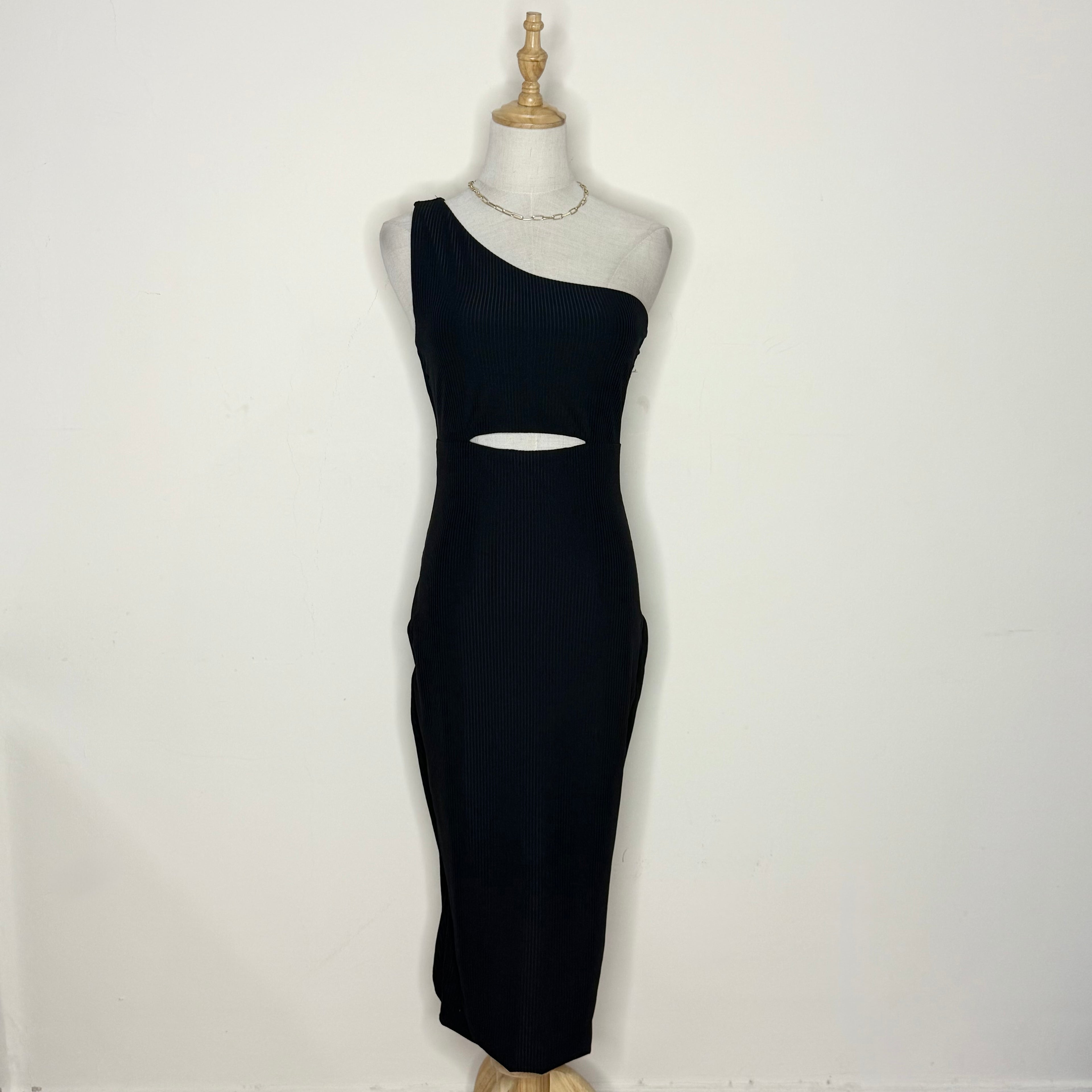 Black one-shoulder dress on a mannequin against a white background