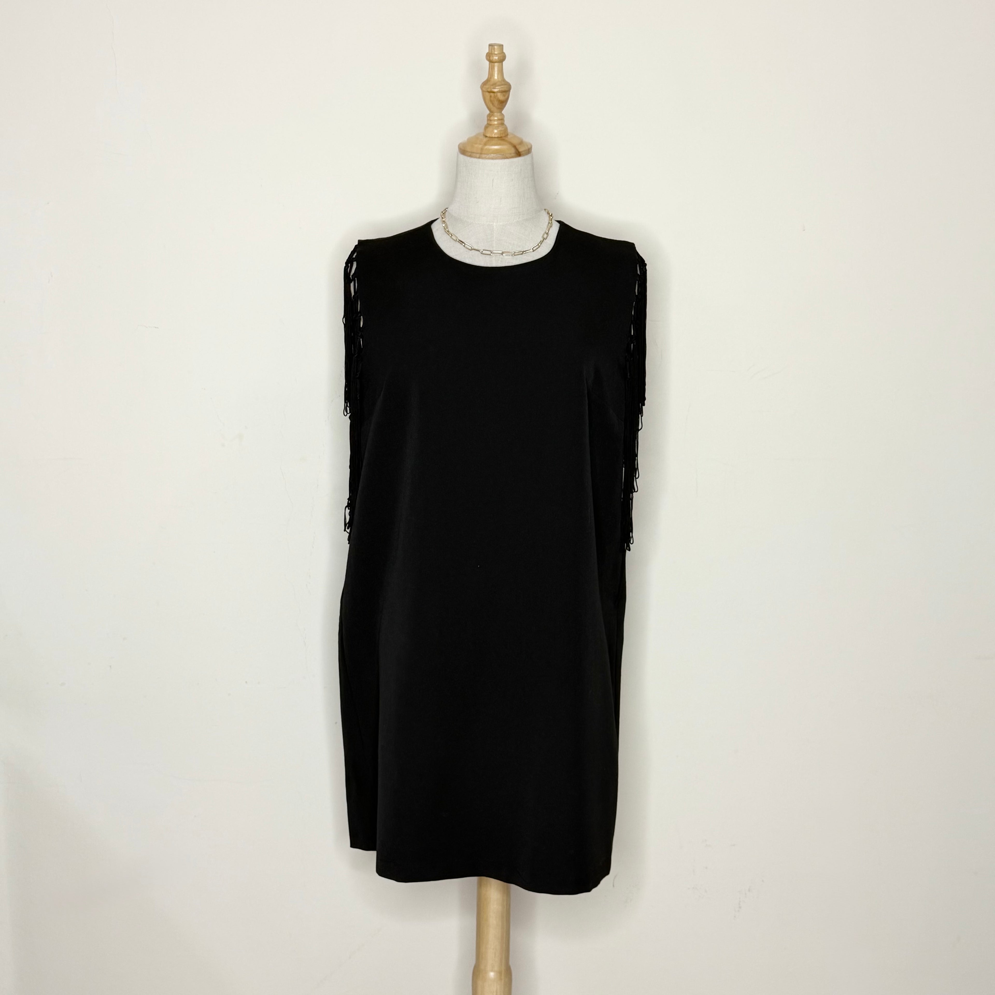 Black sleeveless dress on a mannequin against a white background