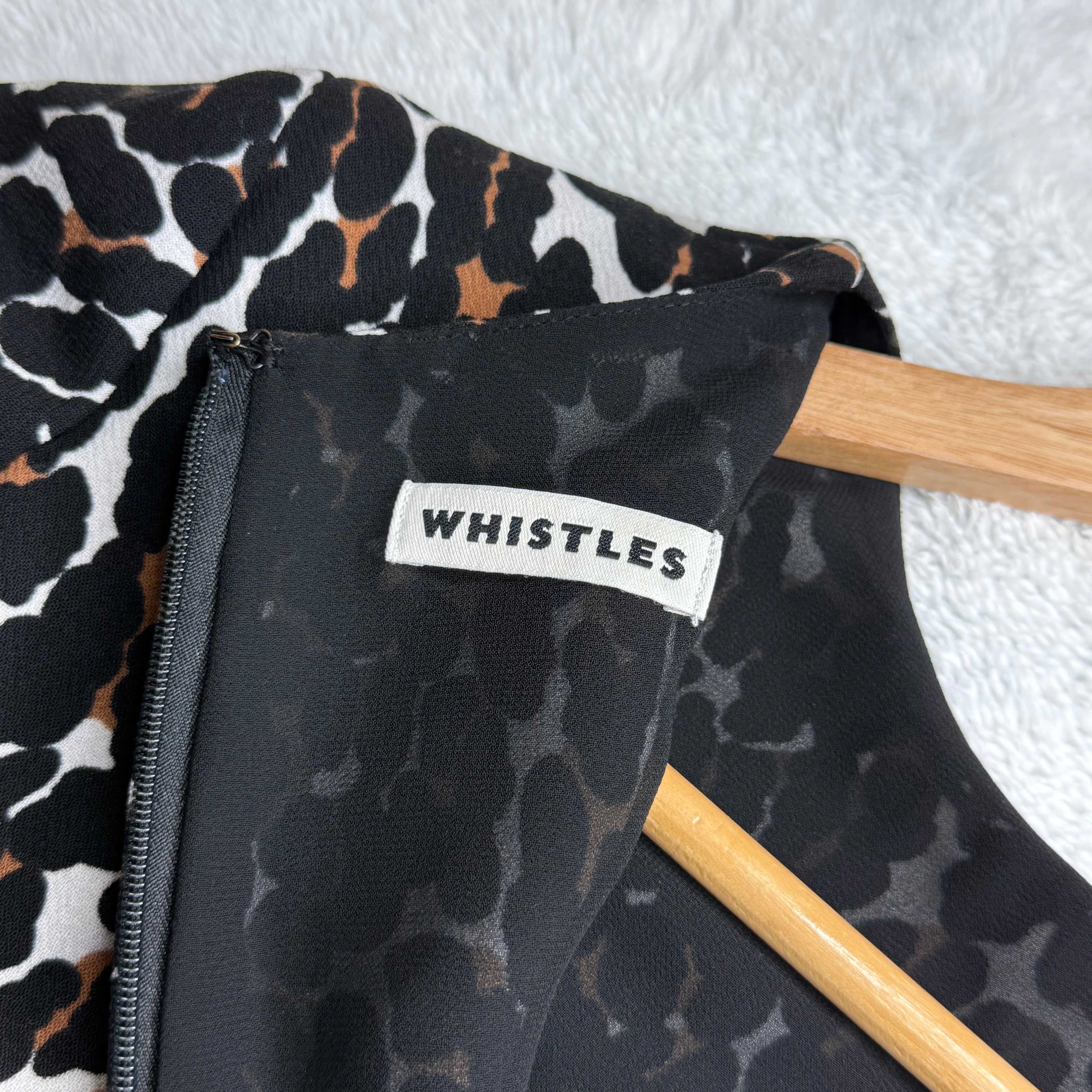 Leopard print garment with a 'Whistles' label on a wooden hanger against a white background