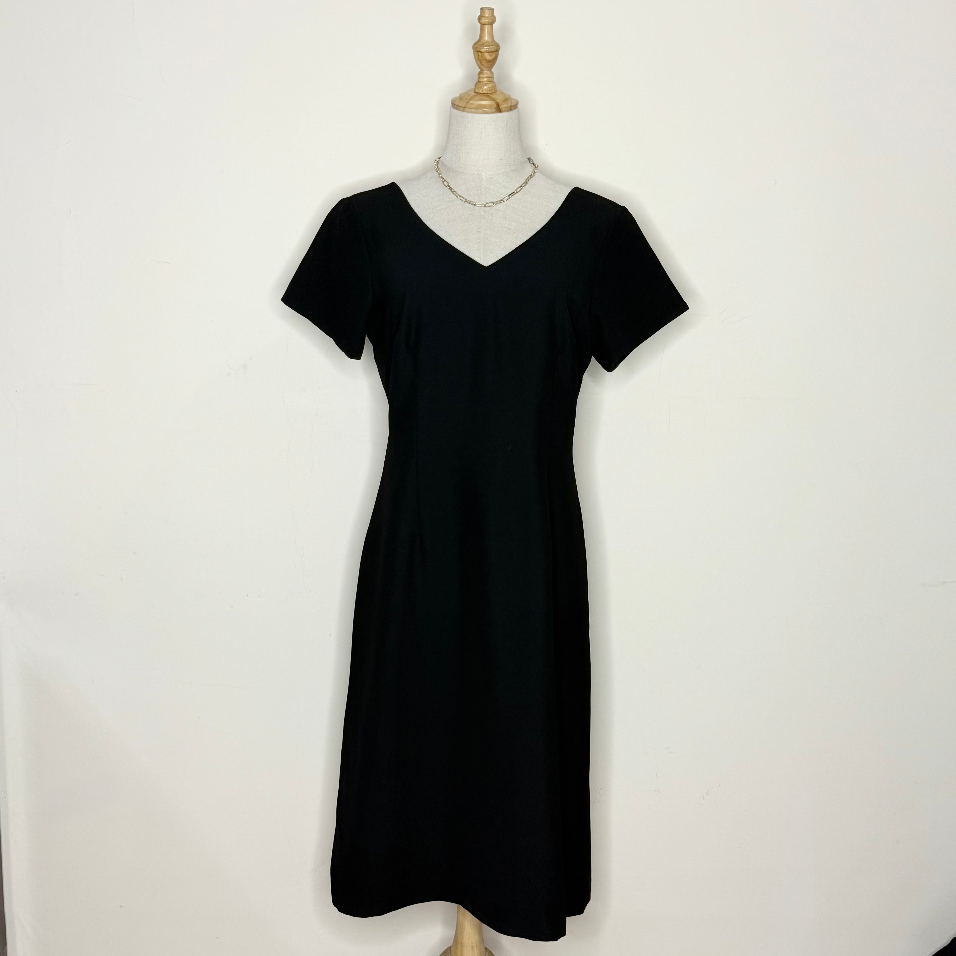 Black dress on a mannequin against a white background