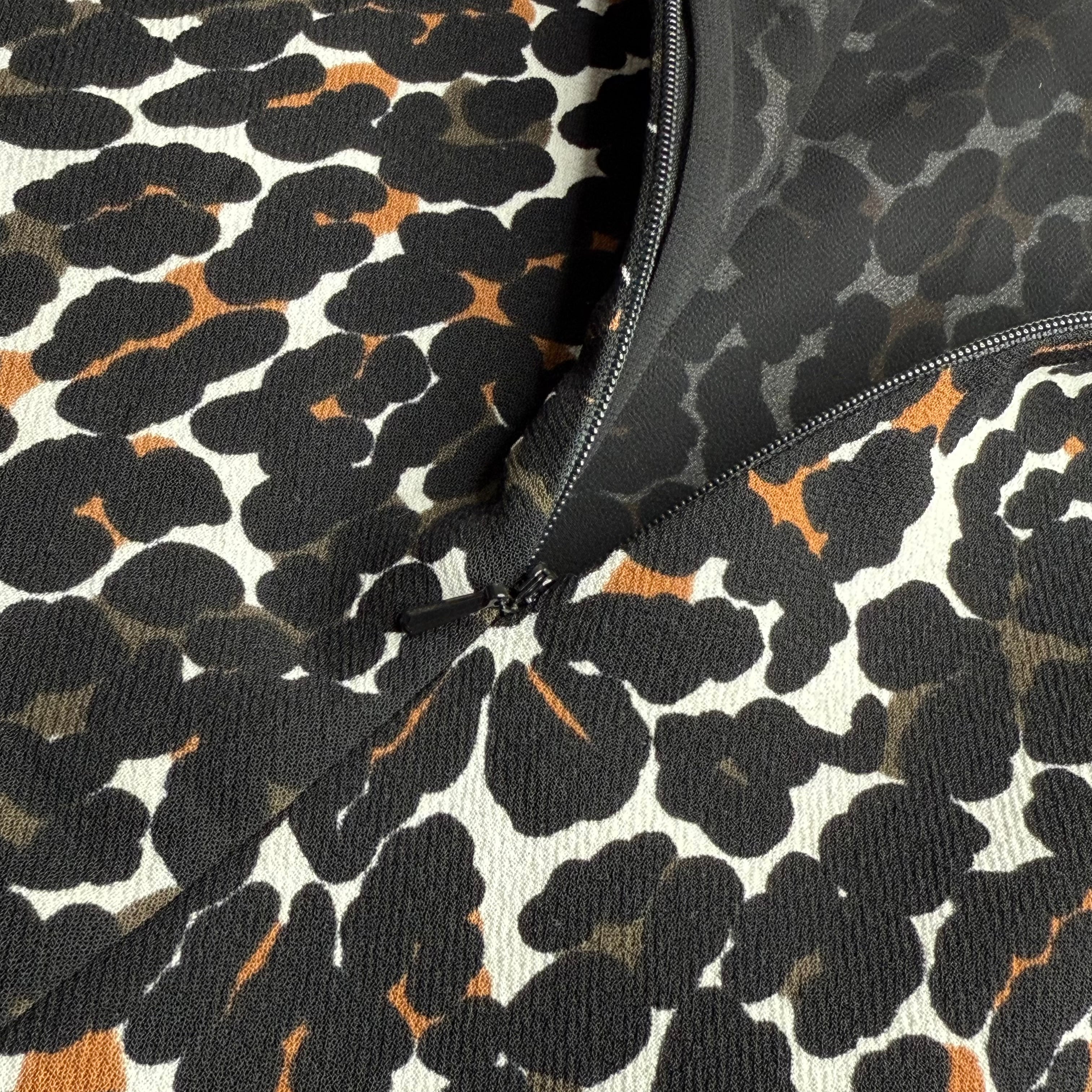 Close-up of a fabric with a black and orange abstract pattern on a white background.