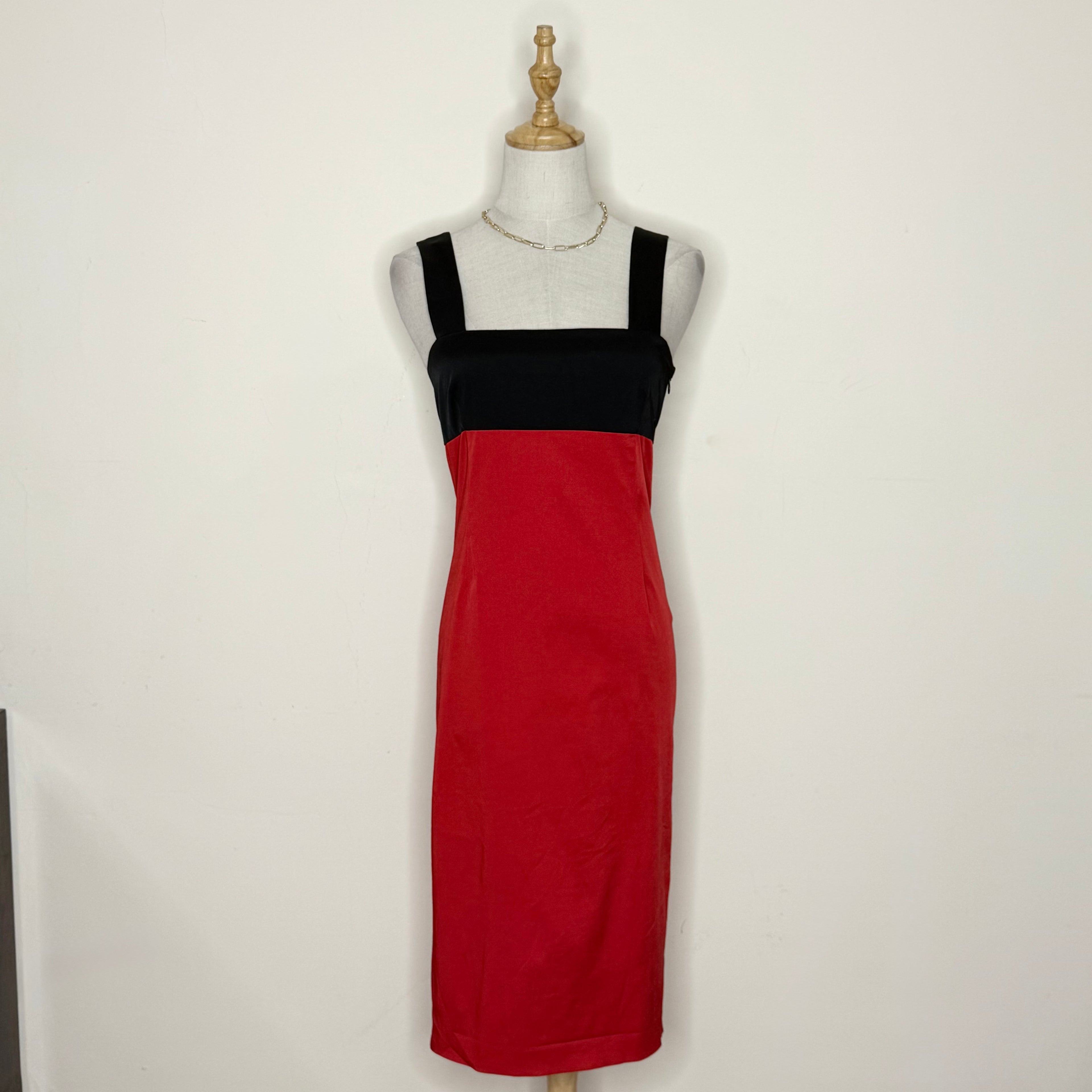 Red and black dress on a mannequin against a white background